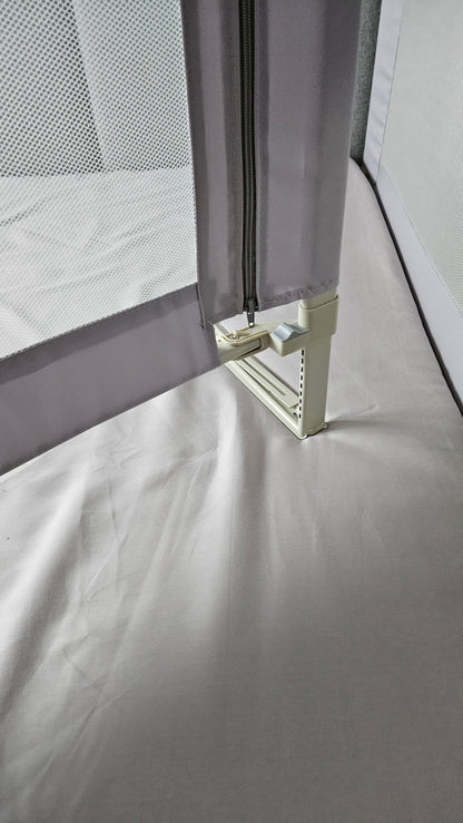 Mesh baby bed rail with zipper and safety latch on a white mattress