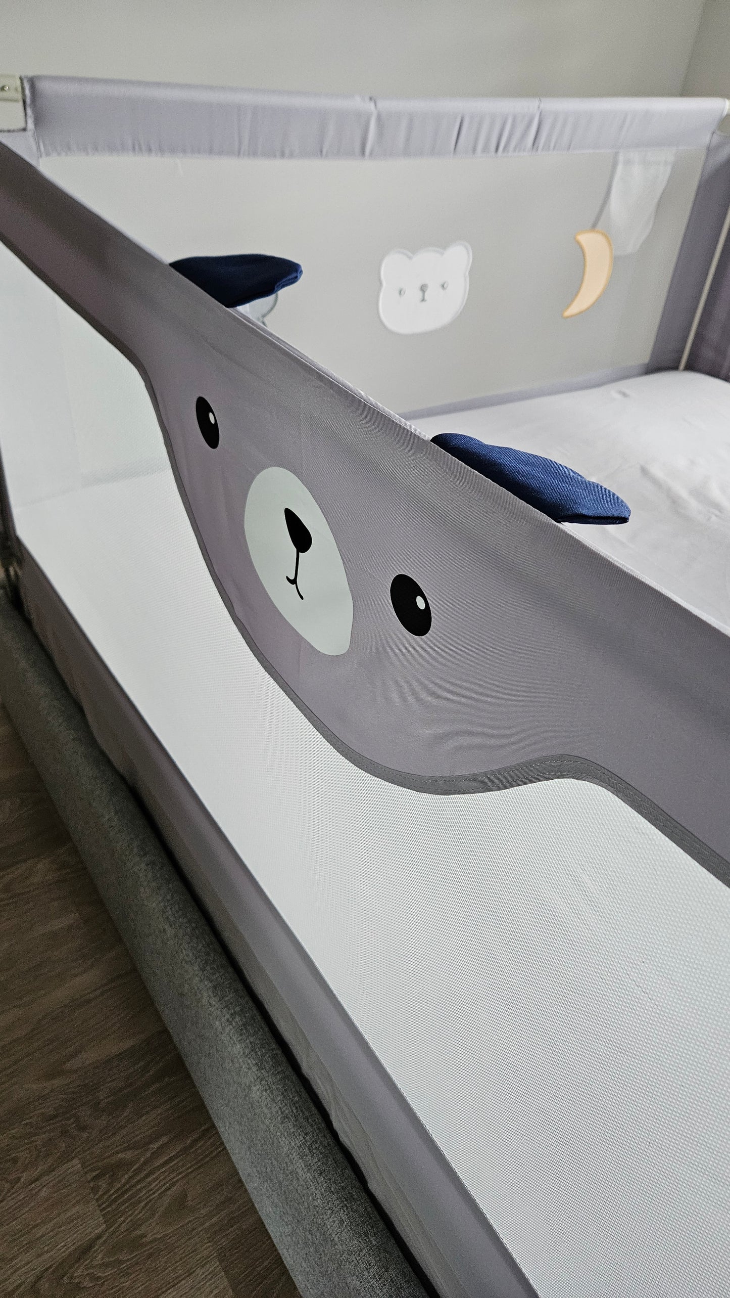 Gray baby crib with cute bear face design, mesh sides, and playful bear and moon motifs