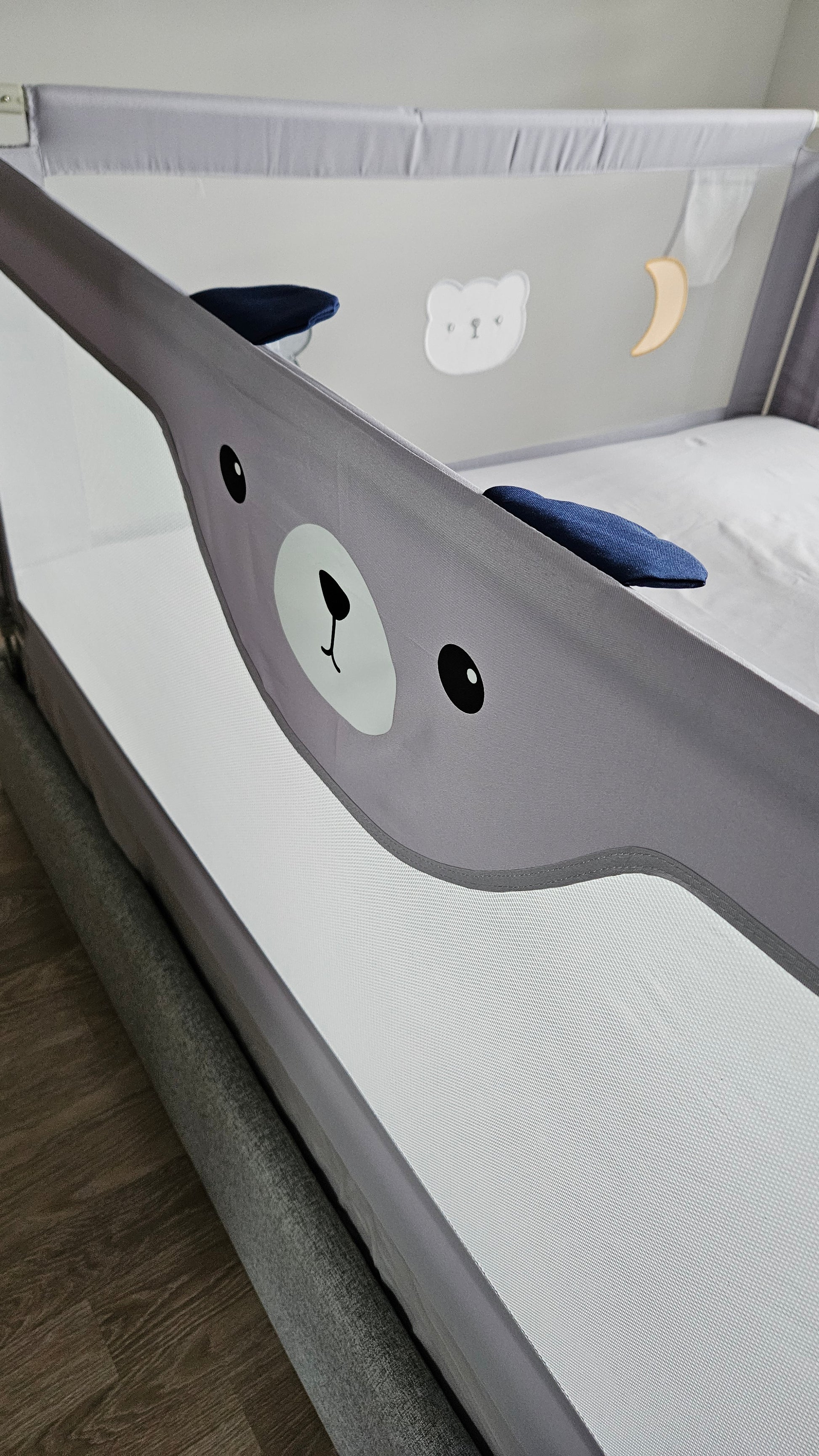 Gray baby crib with cute bear face design, mesh sides, and playful bear and moon motifs