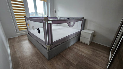 Modern bedroom with safety bed rail, grey bed, white nightstand, and wooden flooring