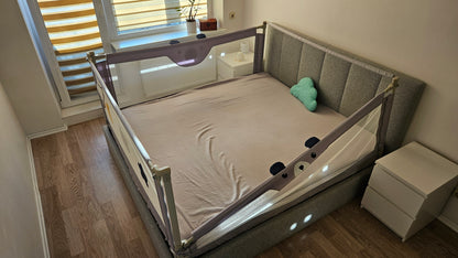 Modern bedroom with grey upholstered bed, safety bed rail, nightstands and cloud pillow